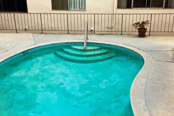 Swimming pool with clear water and steps, indicating potential maintenance and health check needs for pool safety.