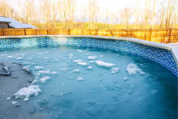 Winter pool with ice and snow, highlighting essential maintenance tips for winter care and renovations by Legendary Pools Inc. Winter pool with ice and snow, highlighting essential maintenance tips for winter care and renovations by Legendary Pools Inc.