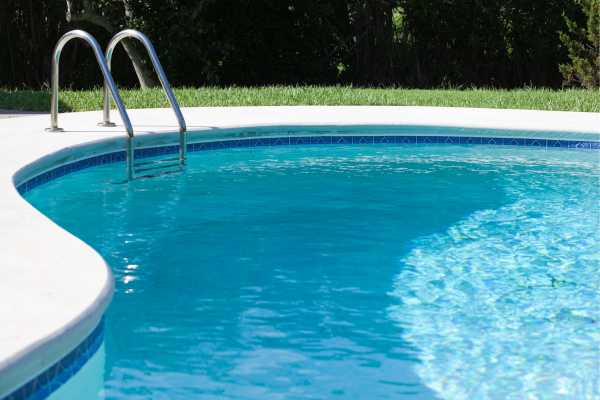 Close-up detail shot of high-quality stone pool coping on a luxury swimming pool in Alamo, California Close-up detail shot of high-quality stone pool coping on a luxury swimming pool in Alamo, California